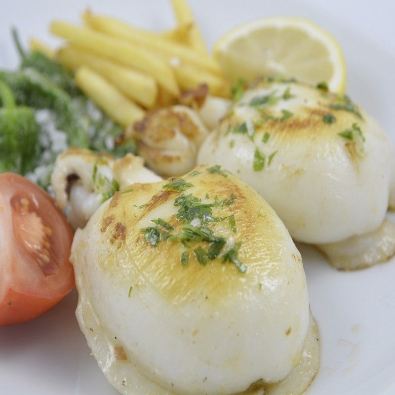 Un plato de espaguetis con salsa de carne y albahaca sobre una mesa de madera.