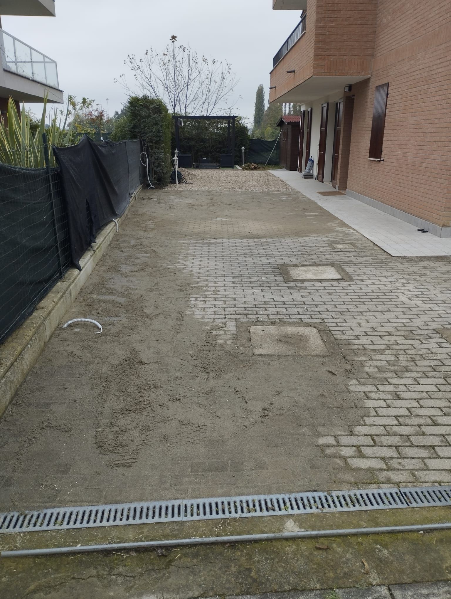 Un vialetto di mattoni con uno scarico al centro