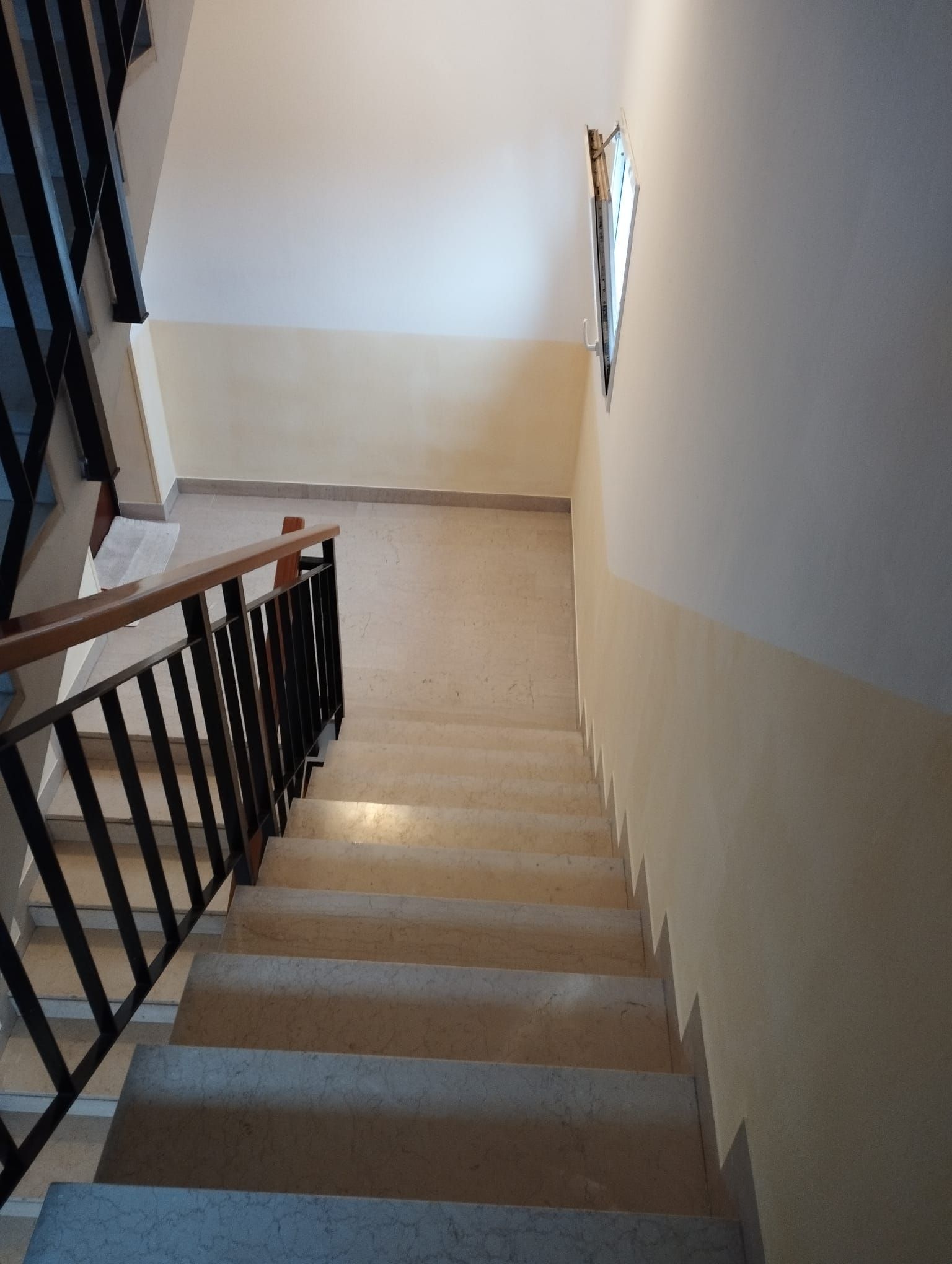 Una scala con ringhiera che sale al secondo piano