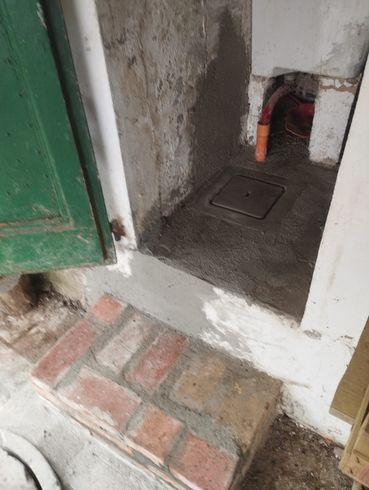 Un passaggio in mattoni che conduce a una porta in un edificio.