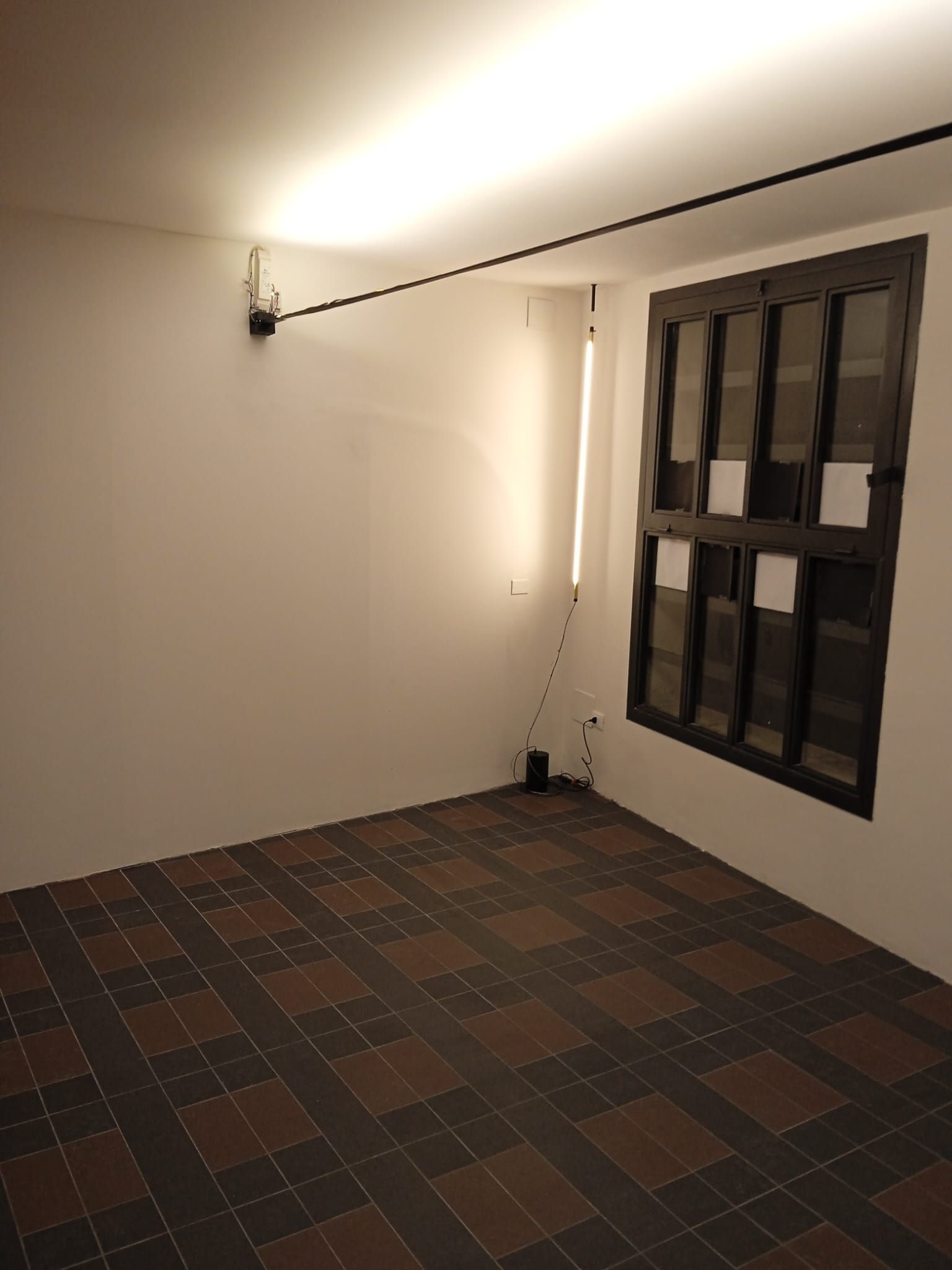 Una stanza vuota con pavimento piastrellato e una finestra