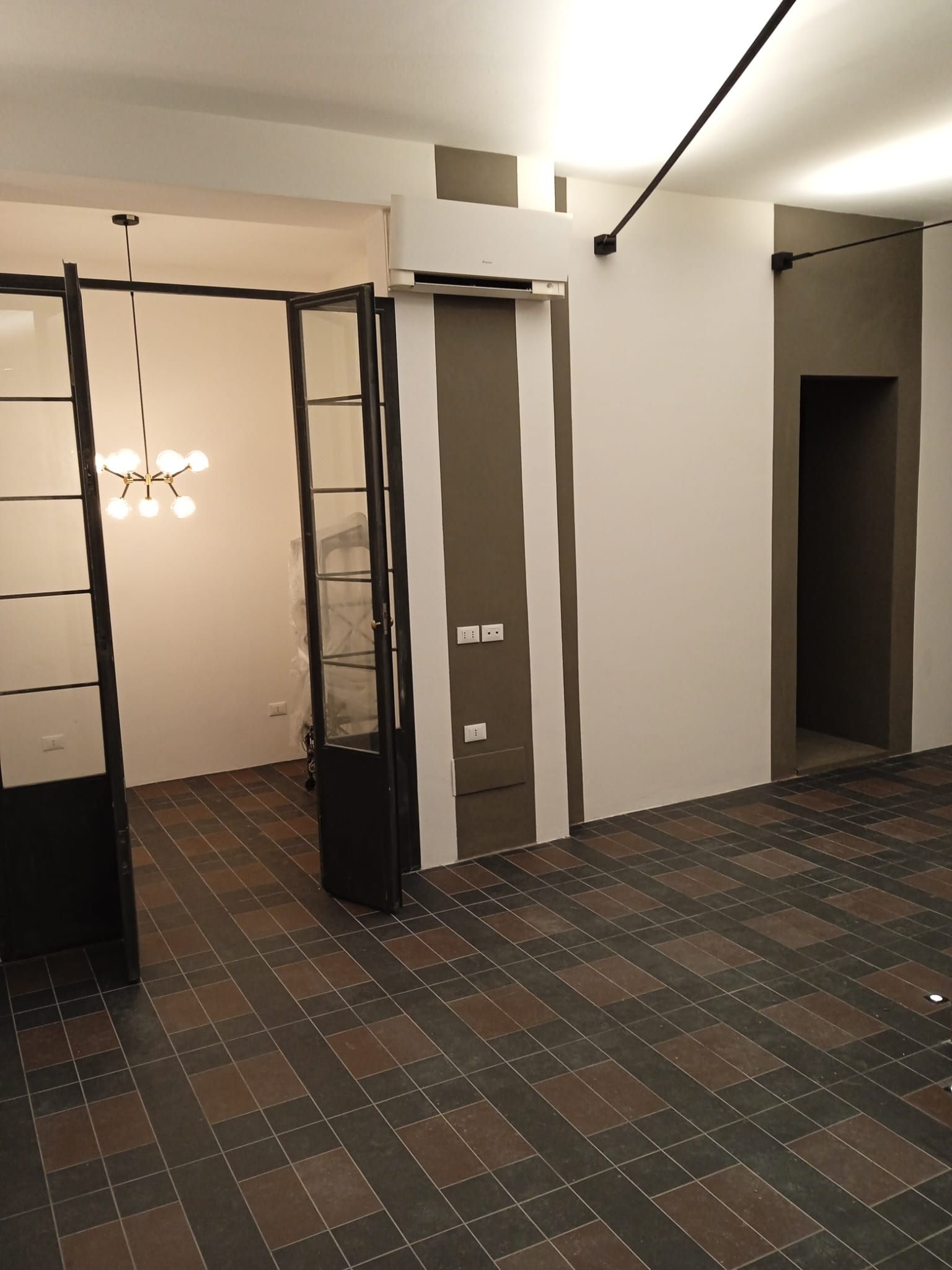 Una stanza vuota con pavimento piastrellato e pareti bianche