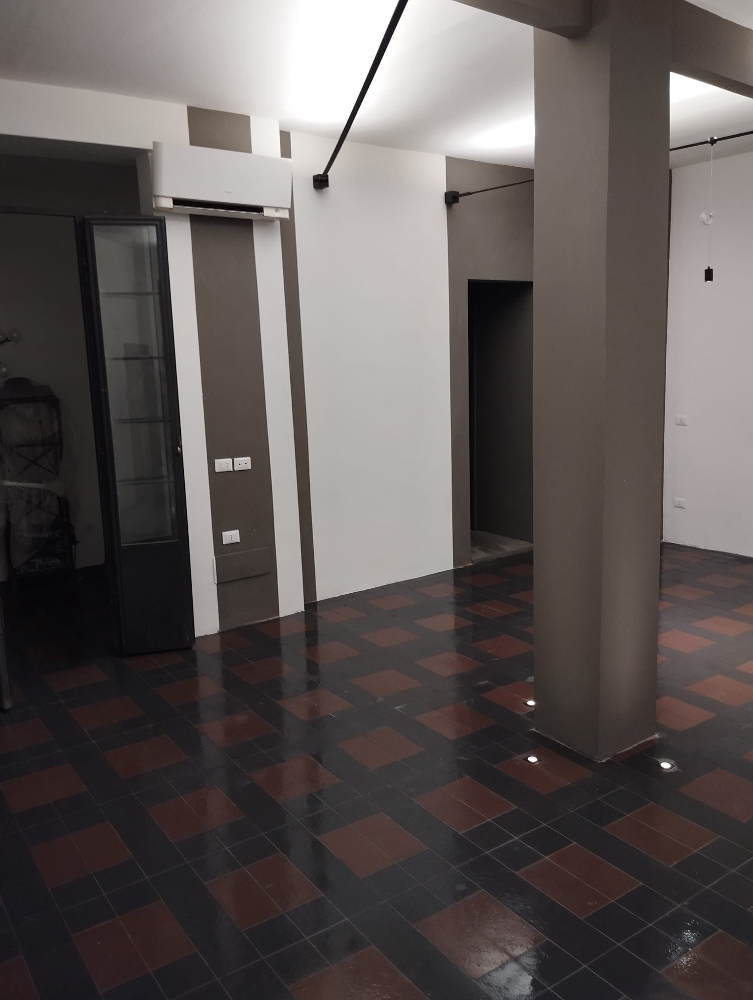 Una stanza vuota con pavimento a scacchi e pareti bianche