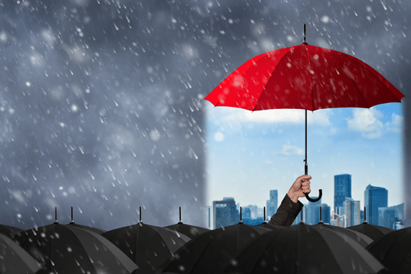 A person is holding a red umbrella over a city