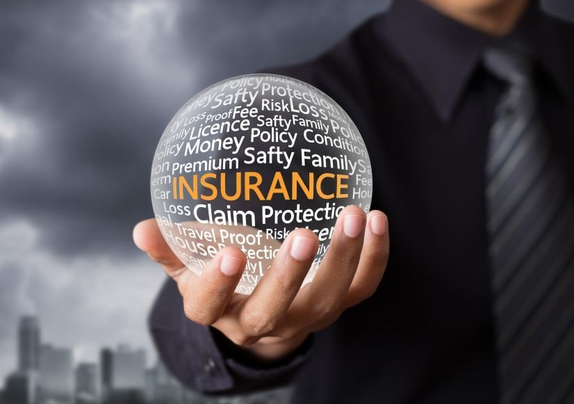 A man is holding a glass ball with the word insurance on it