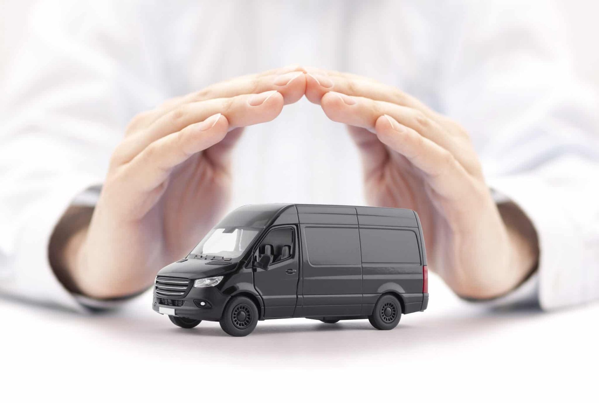 A person is holding a black van in their hands.