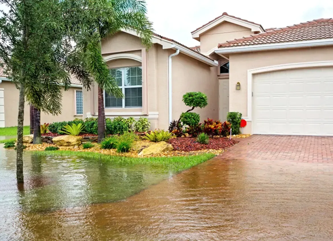 A flooded driveway in front of a house.