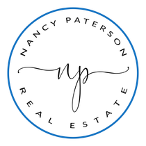 The logo for nancy paterson real estate is a blue circle with the name nancy paterson written inside of it.
