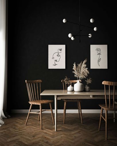 A dining room with a table and chairs and black walls