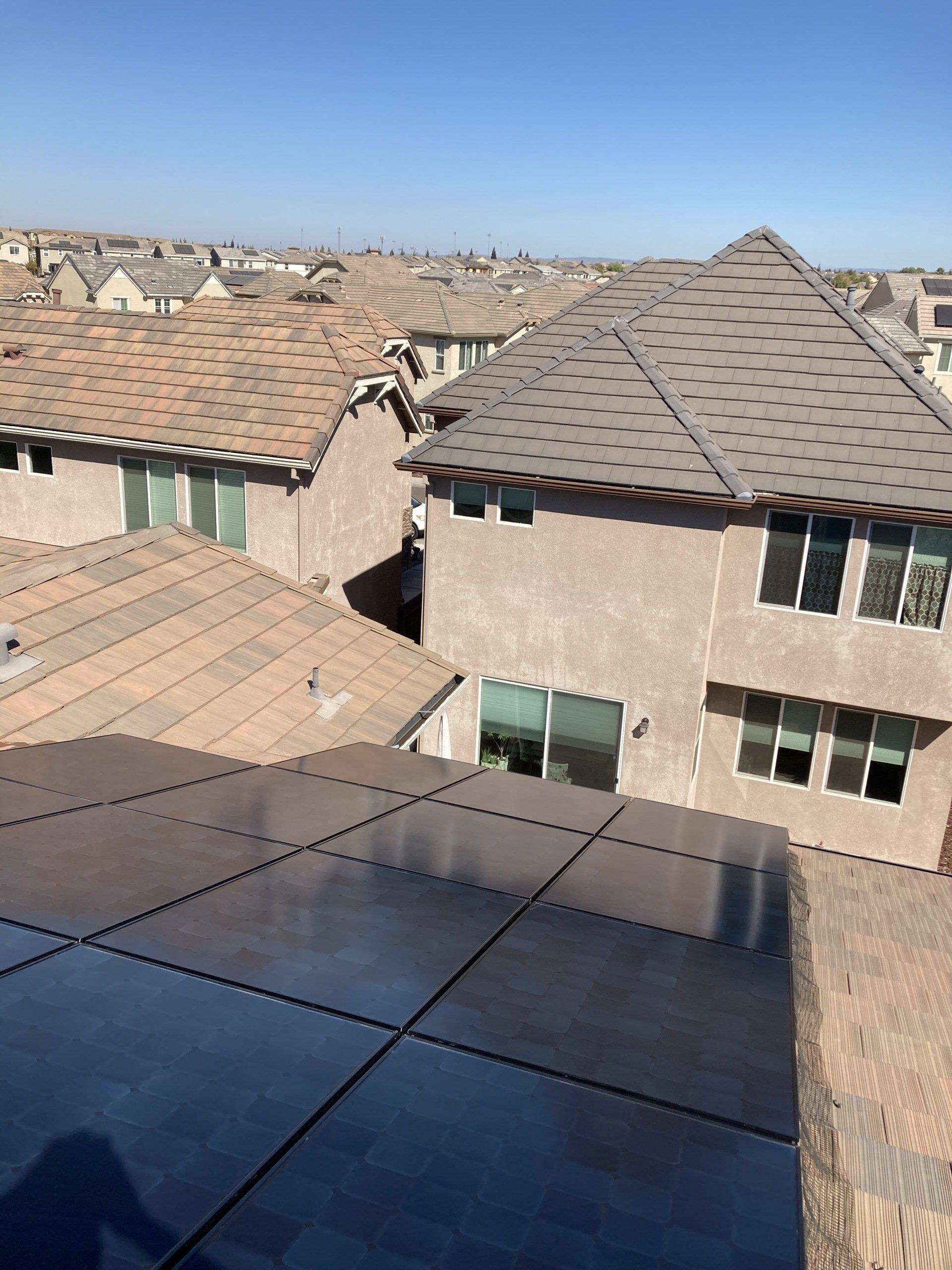 An aerial view of a row of houses with a blue sky in the background
