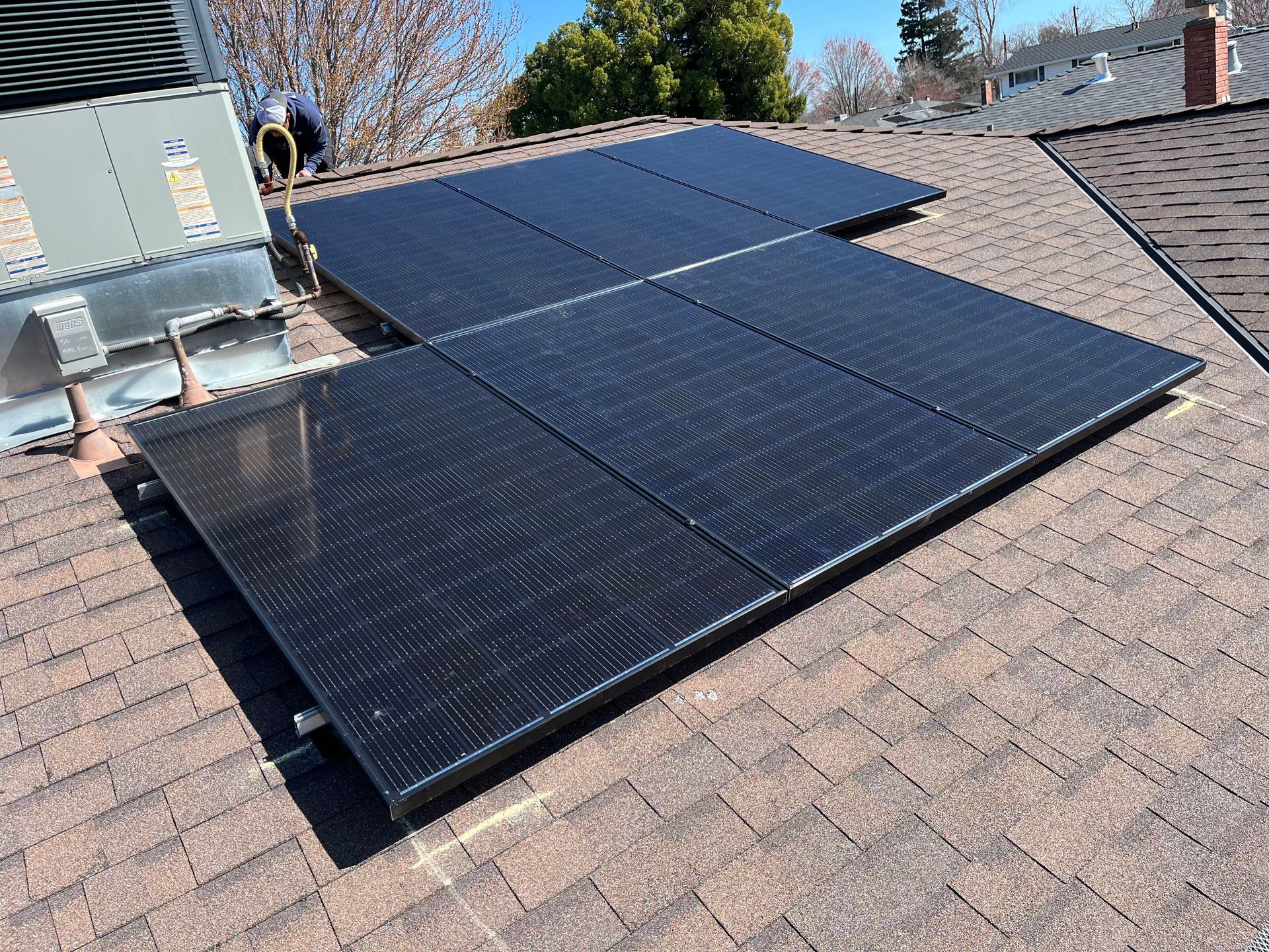 A row of solar panels are sitting on top of a roof.