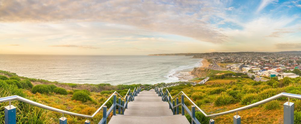 A Staircase Leading Up To A Beach With A View Of The Ocean — MC Plastering In Newcastle, NSW