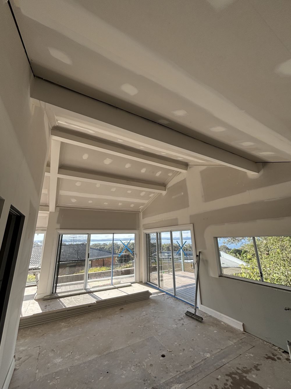 An Empty Room With A Lot Of Windows And A Broom — MC Plastering In Fingal Bay, NSW