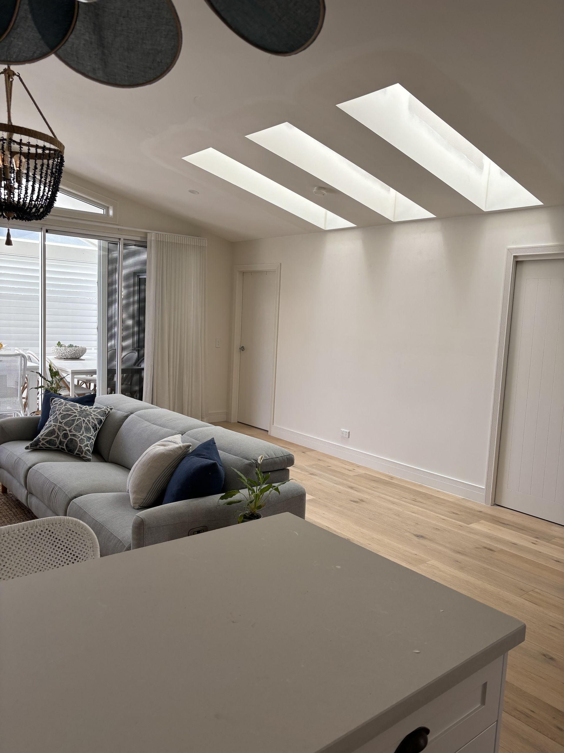 A Living Room With A Couch And A Chandelier — MC Plastering In Maitland, NSW