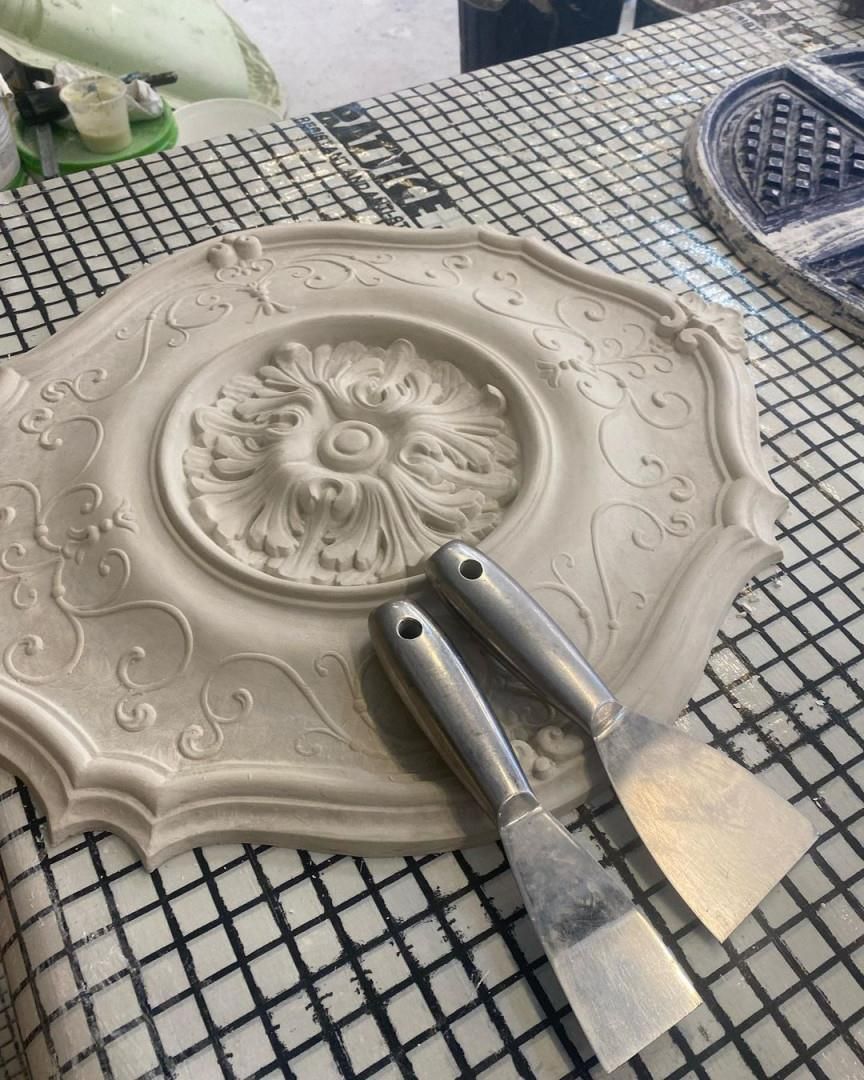 Two Spatulas Are Sitting On Top Of A White Plate On A Table — MC Plastering In Maitland, NSW