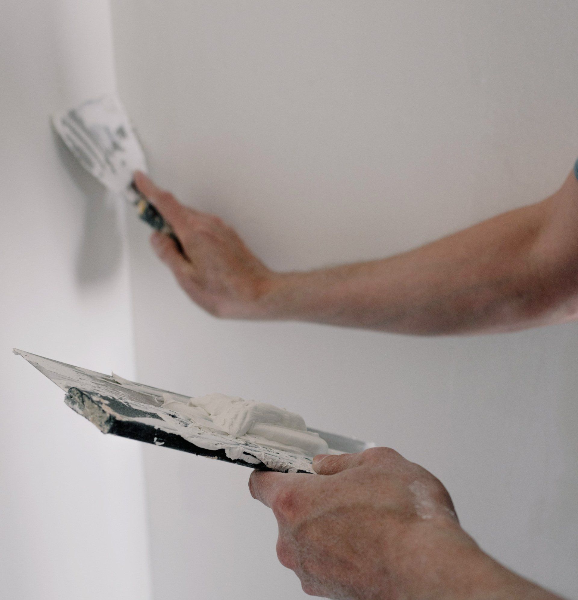 An experienced professional applying spackle to repair and smooth out wall surfaces.