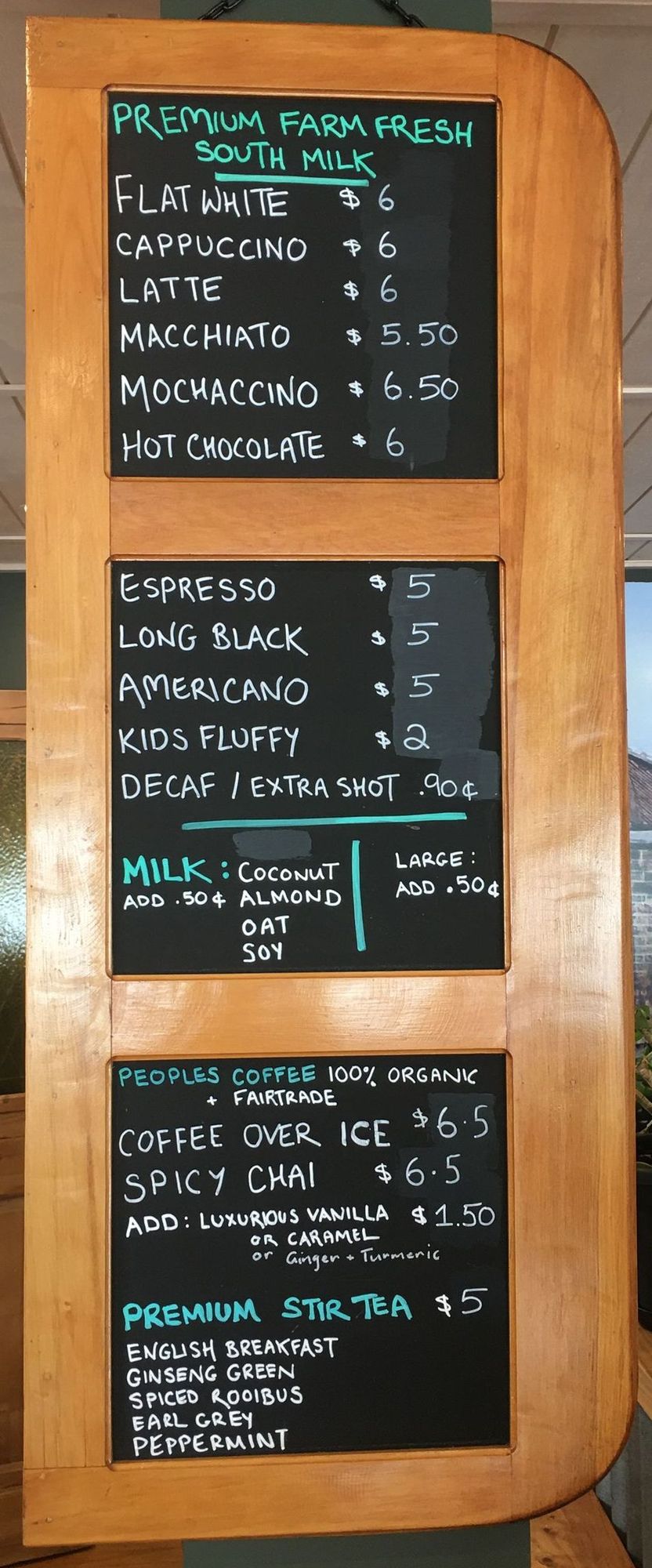 a chalkboard menu of coffee and tea at recharge bar, premium farm fresh south milk, peoples organic coffee, fairtrade, 