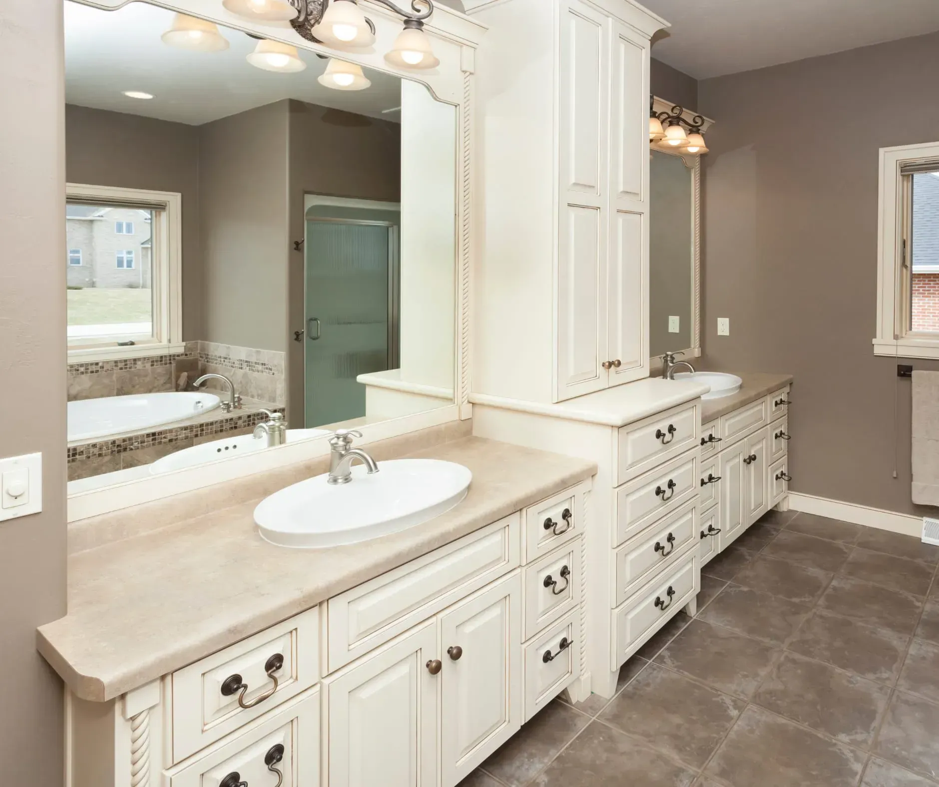 Elegant bathroom with cream cabinets, stone countertops, and large mirror over the vanity.