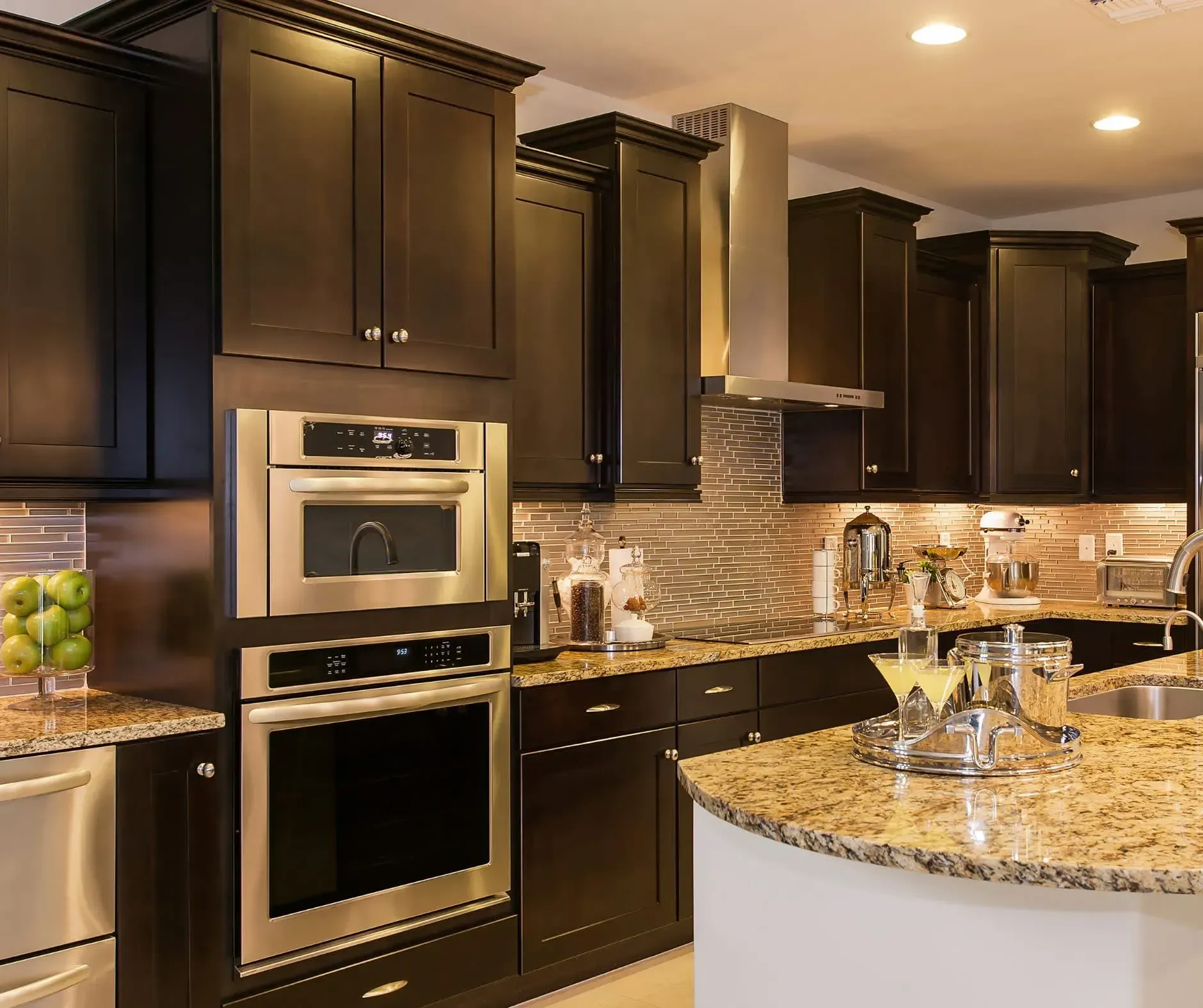 Dark wood kitchen with stainless steel appliances, granite countertops.