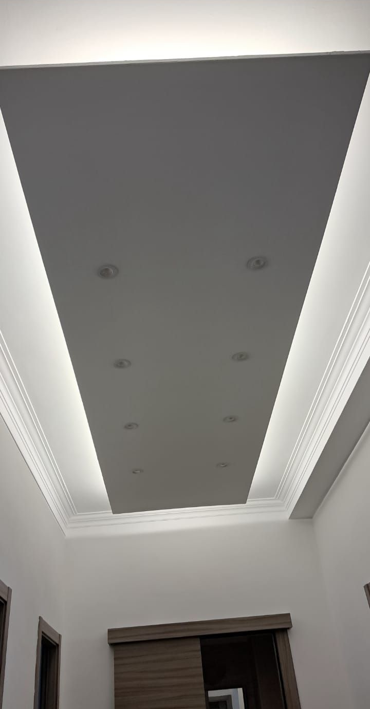 Soffitto bianco con illuminazione da incasso e strisce perimetrali illuminate.