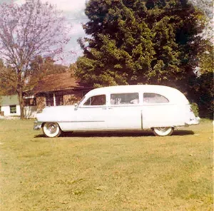 Old white hearse on grass Mynatt Funeral Home, Inc.