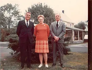Older photo of three Mynatt Funeral Home staff two male and one female in the center