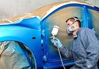 Worker painting blue car. – auto body repair in Huntley, IL