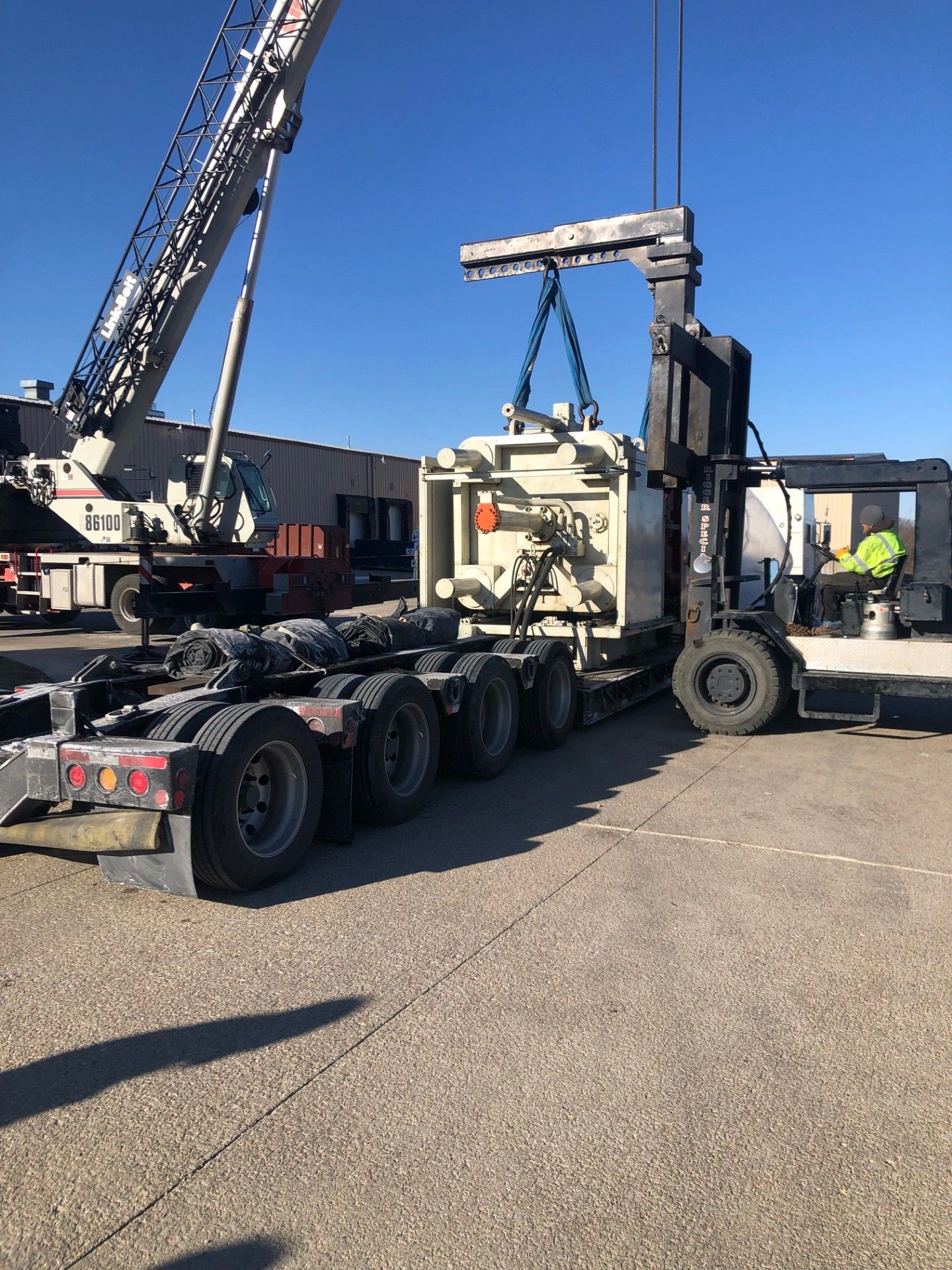Yellow and black printing press machine in a factory setting.