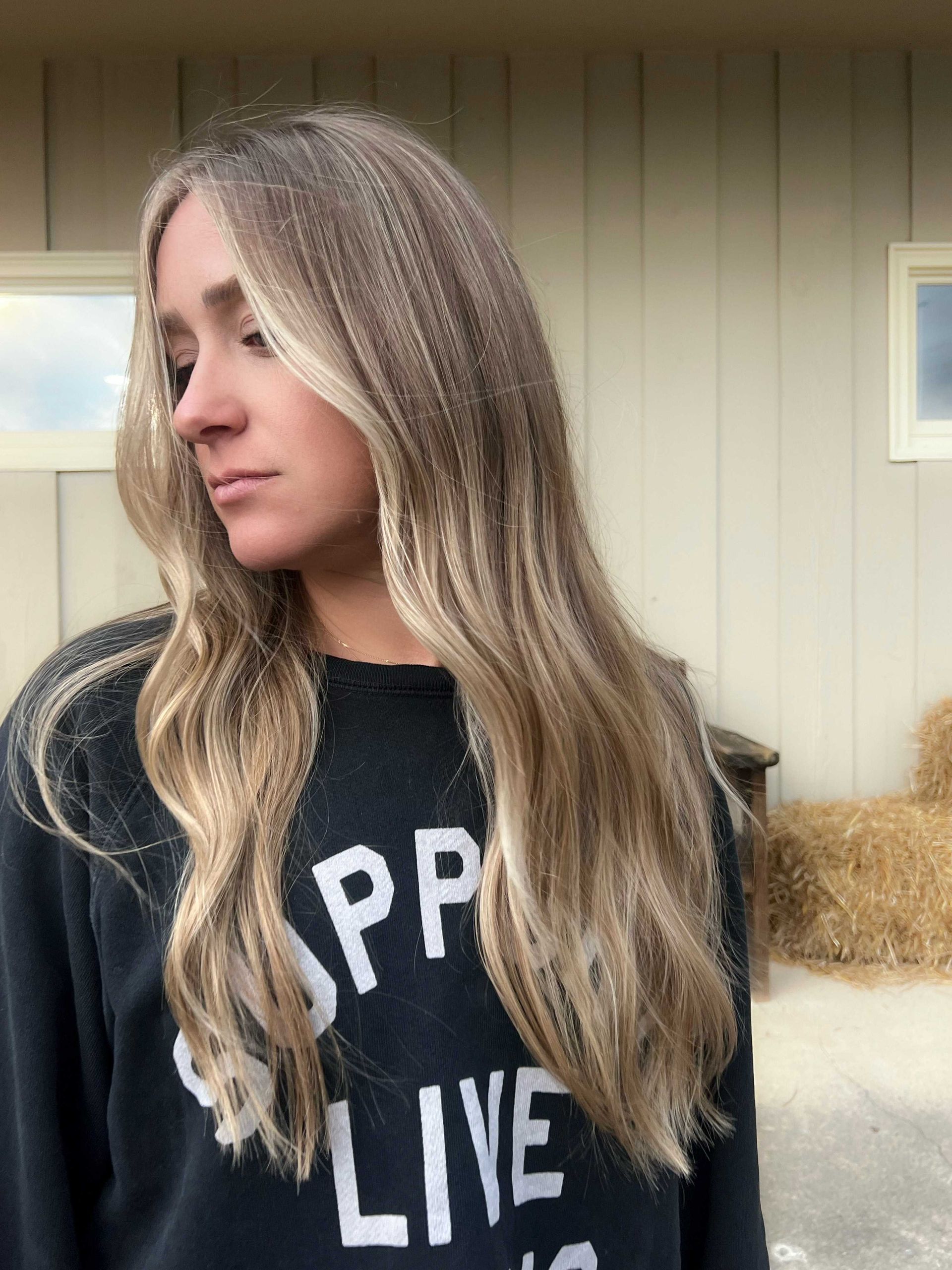 Woman with long blonde highlighted new hair style from blonding specialist custom color