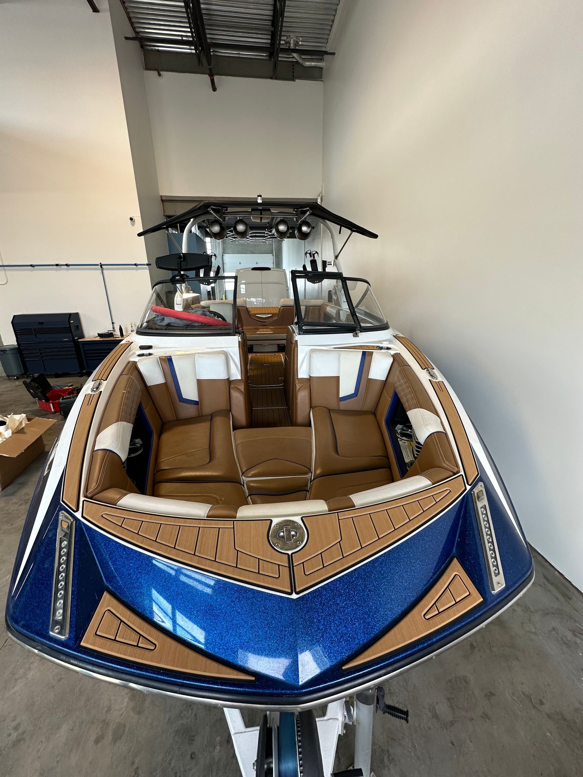 A blue and brown boat is sitting in a warehouse.