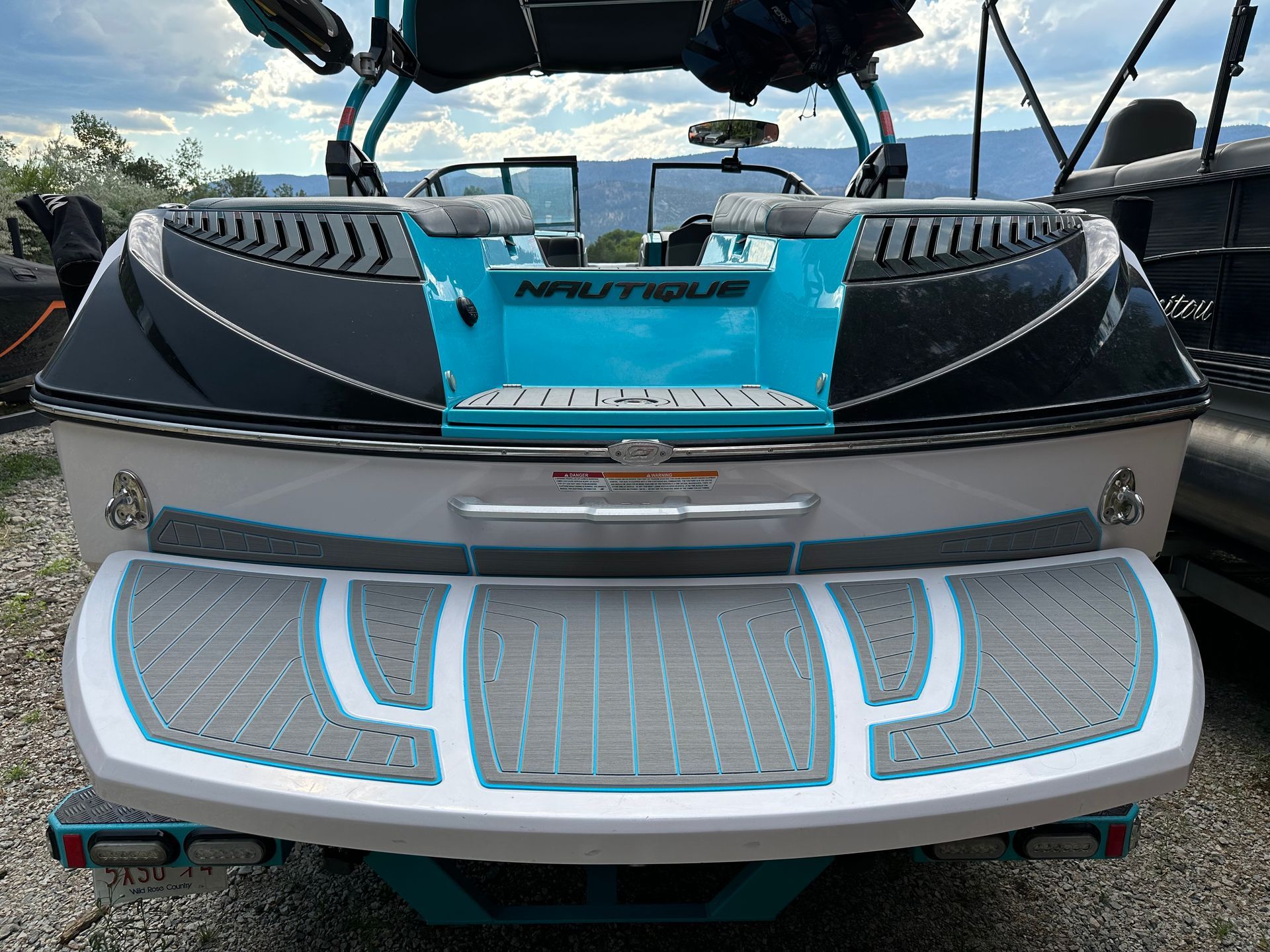 The back of a boat with a blue and white cushion on it.