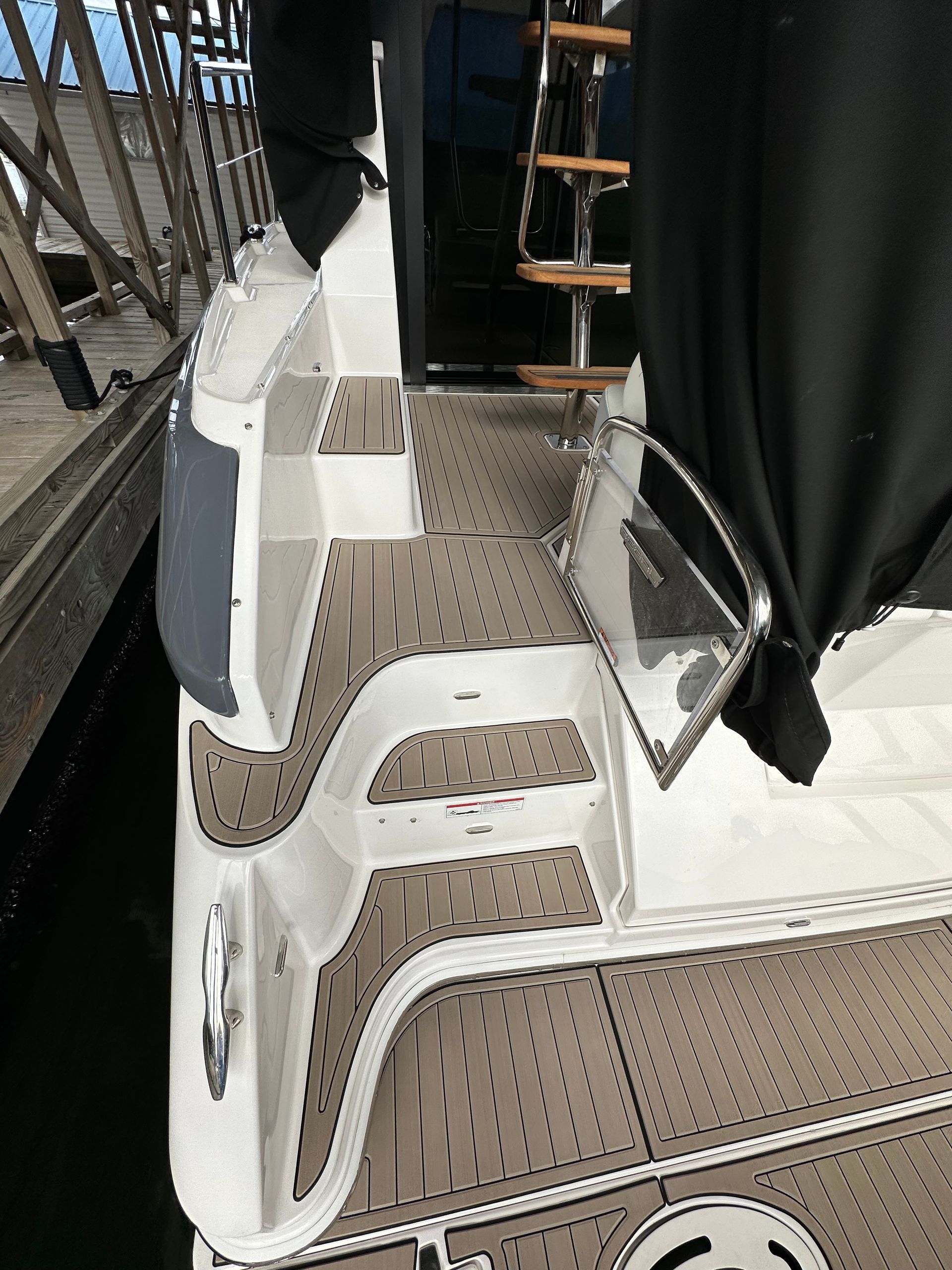 A boat is docked at a dock with a black cover on it.