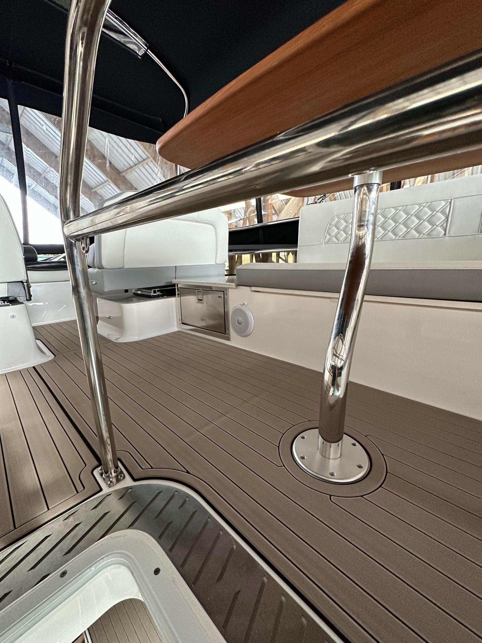 A boat with a stainless steel railing and a wooden seat