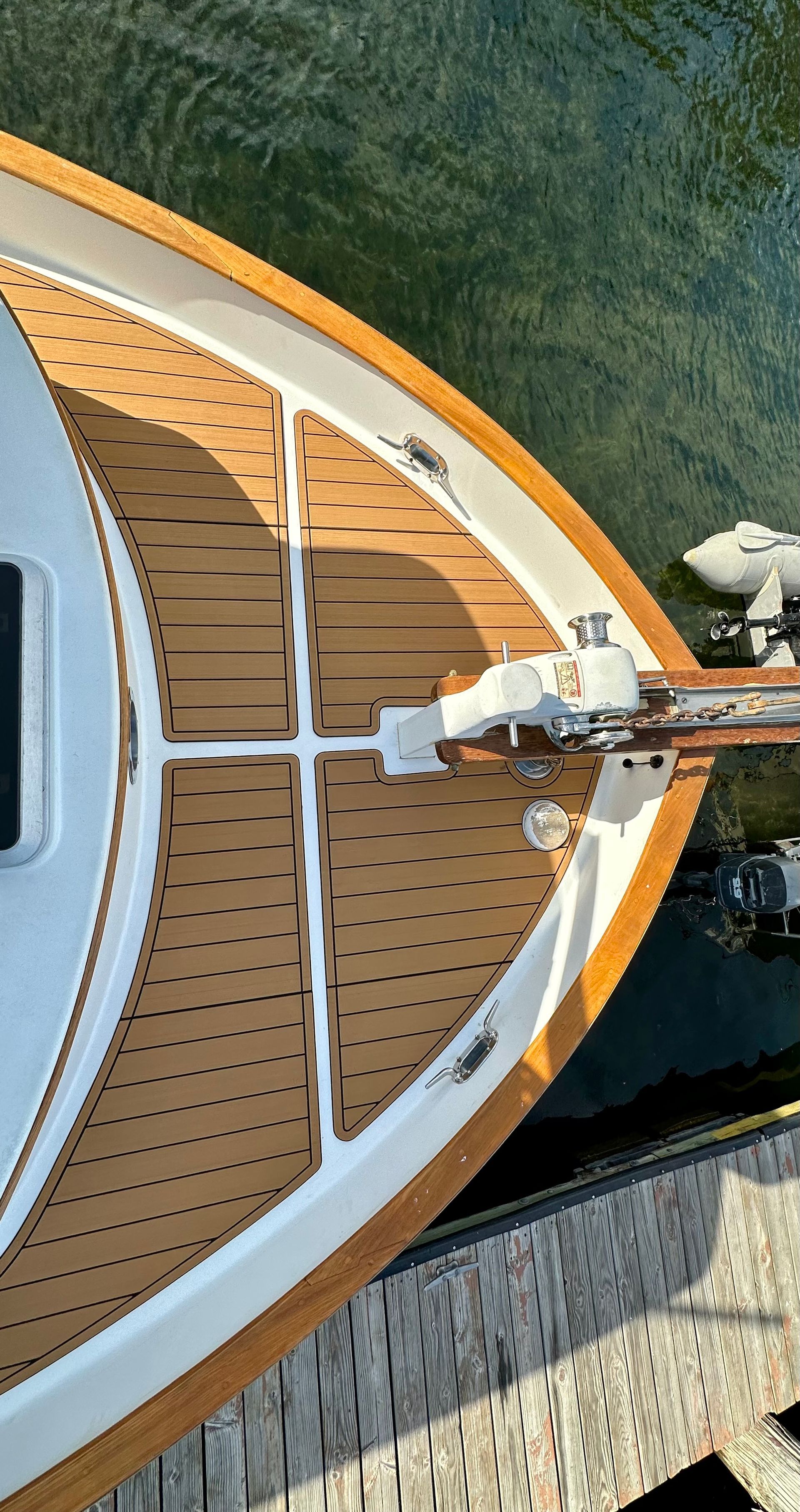 A boat with a wooden deck is docked in the water.