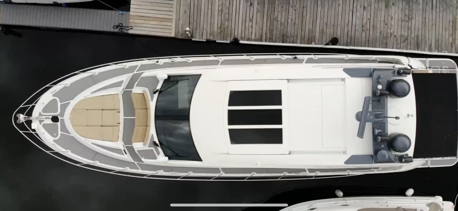 An aerial view of a large white yacht docked at a dock.