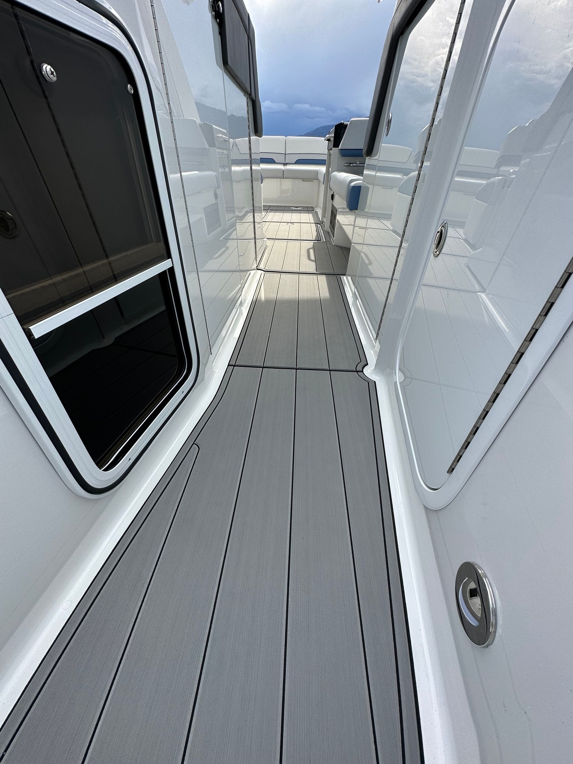 A white boat with a gray deck and a gray carpeted floor.