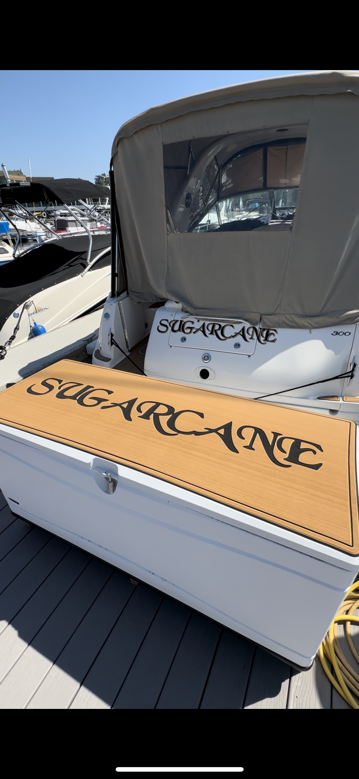 A boat is docked at a dock with a cooler on the back of it.
