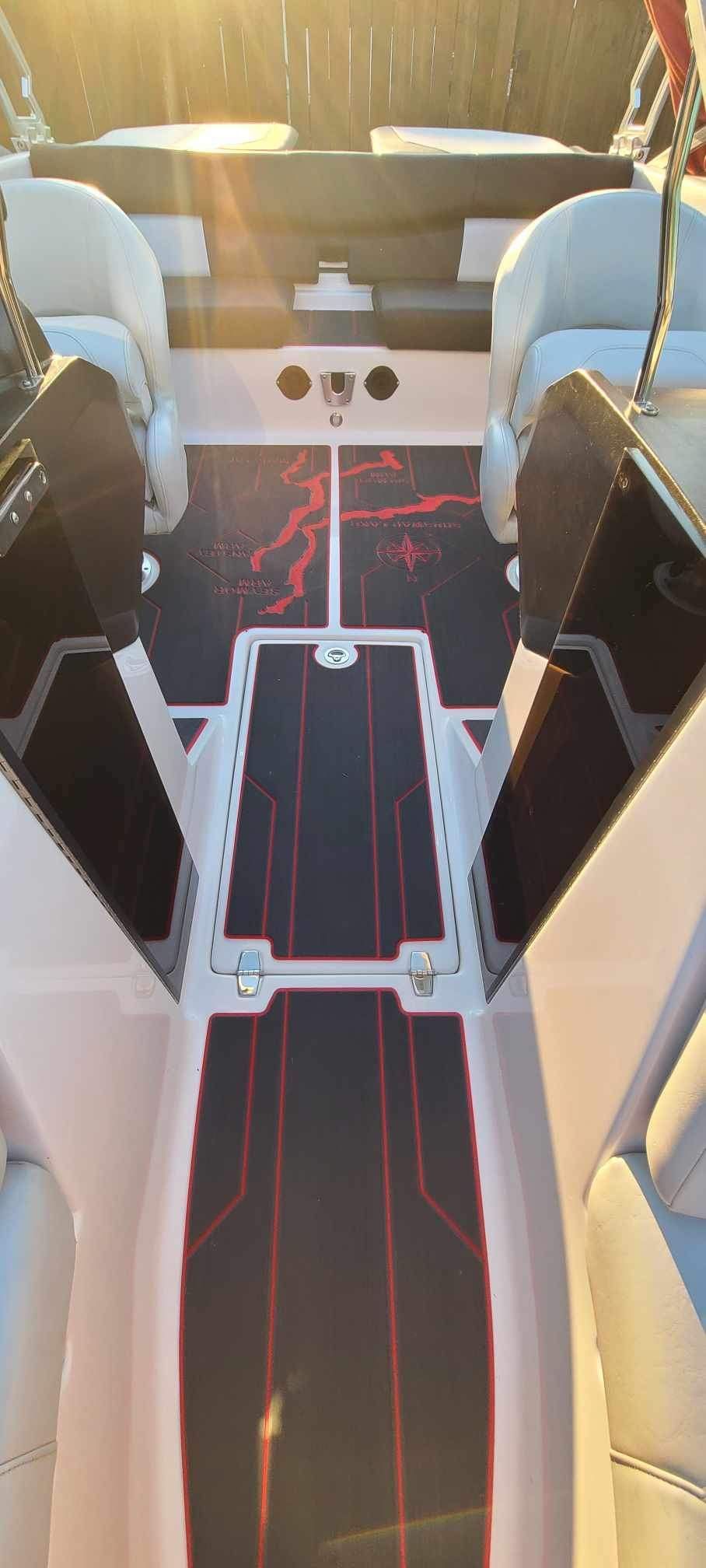 The inside of a boat with a red and black carpet.