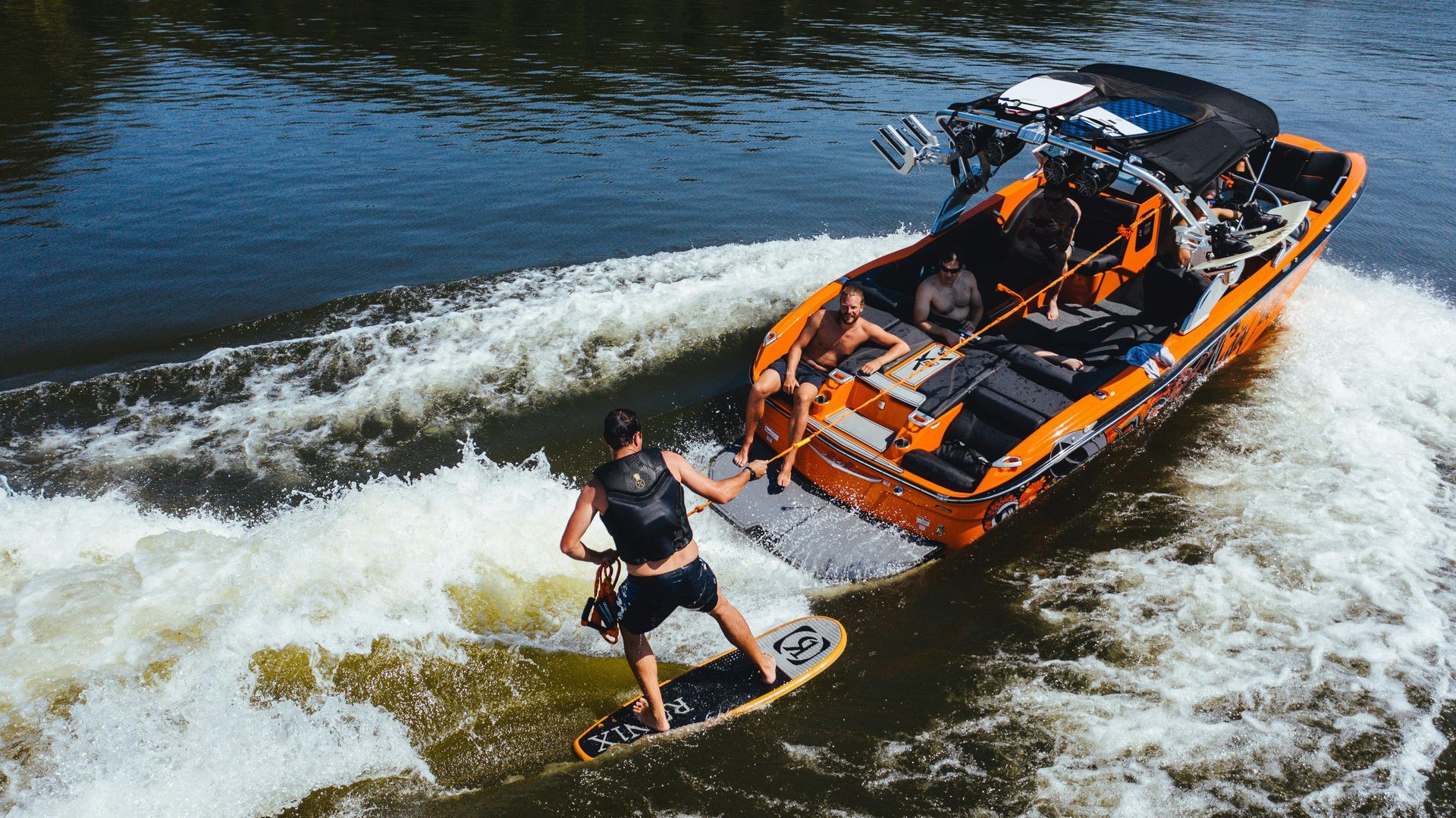 A man is riding a wave on a wakeboard in the water.