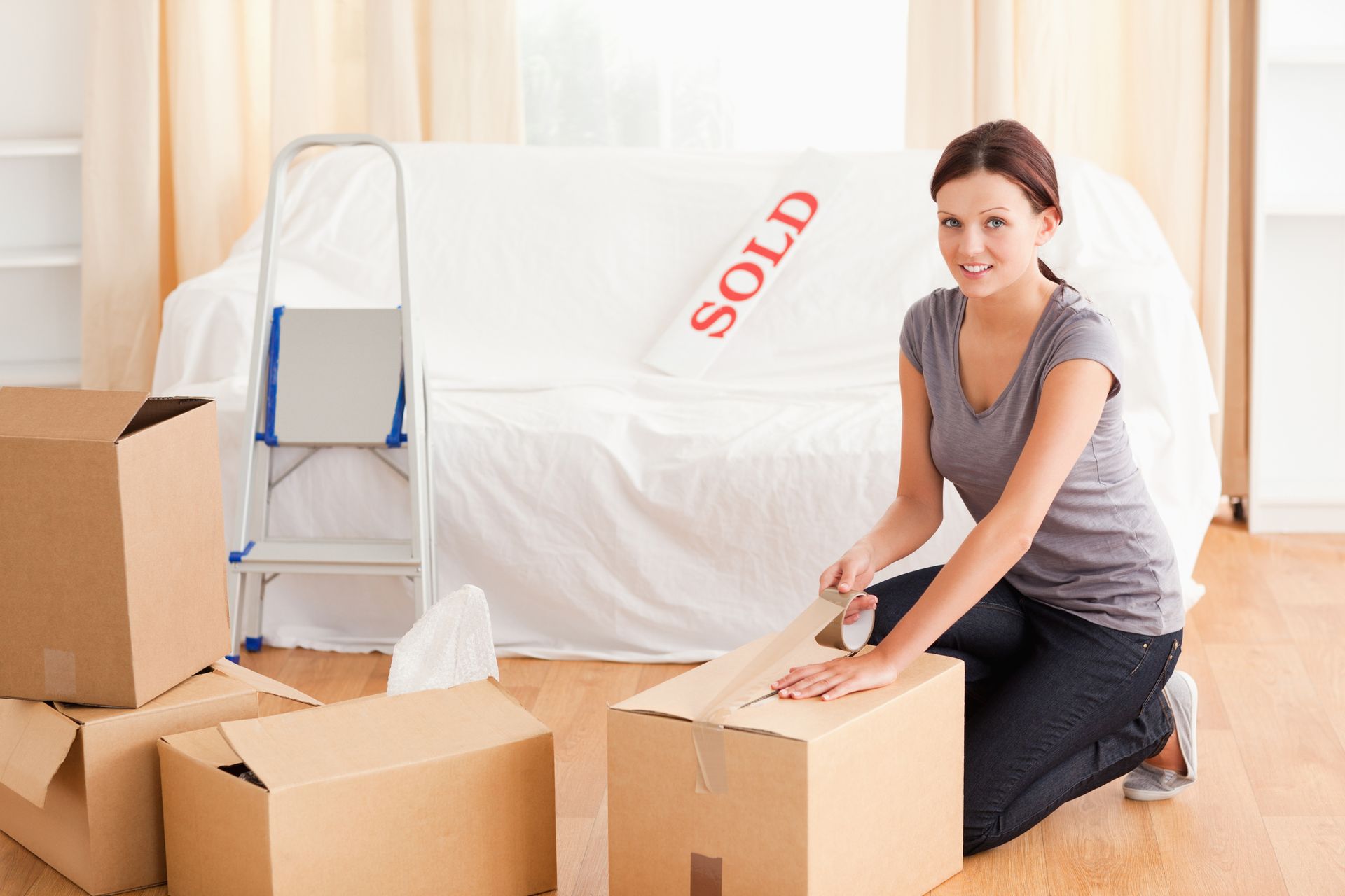 A woman packing boxes and preparing for professional removals