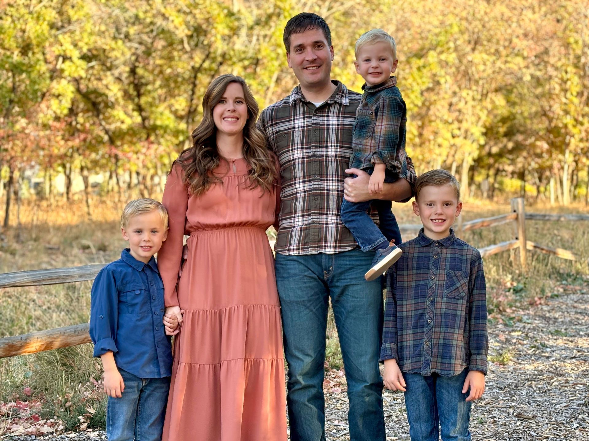 A family is posing for a picture together in a field.