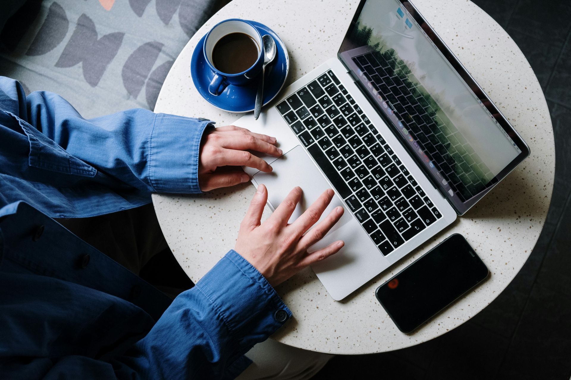 A person is sitting at a table using a laptop computer with MRU Internet.