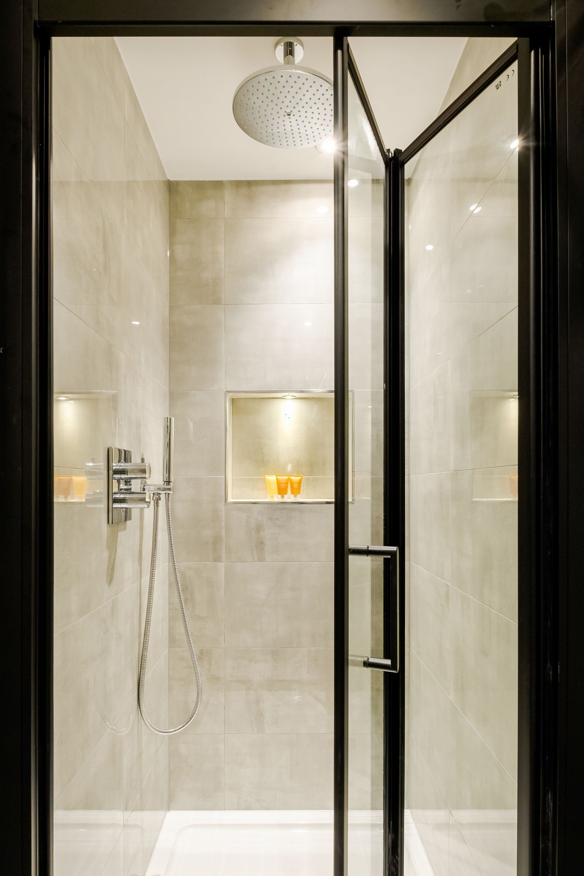 A shower stall with a black frame and a shower head.