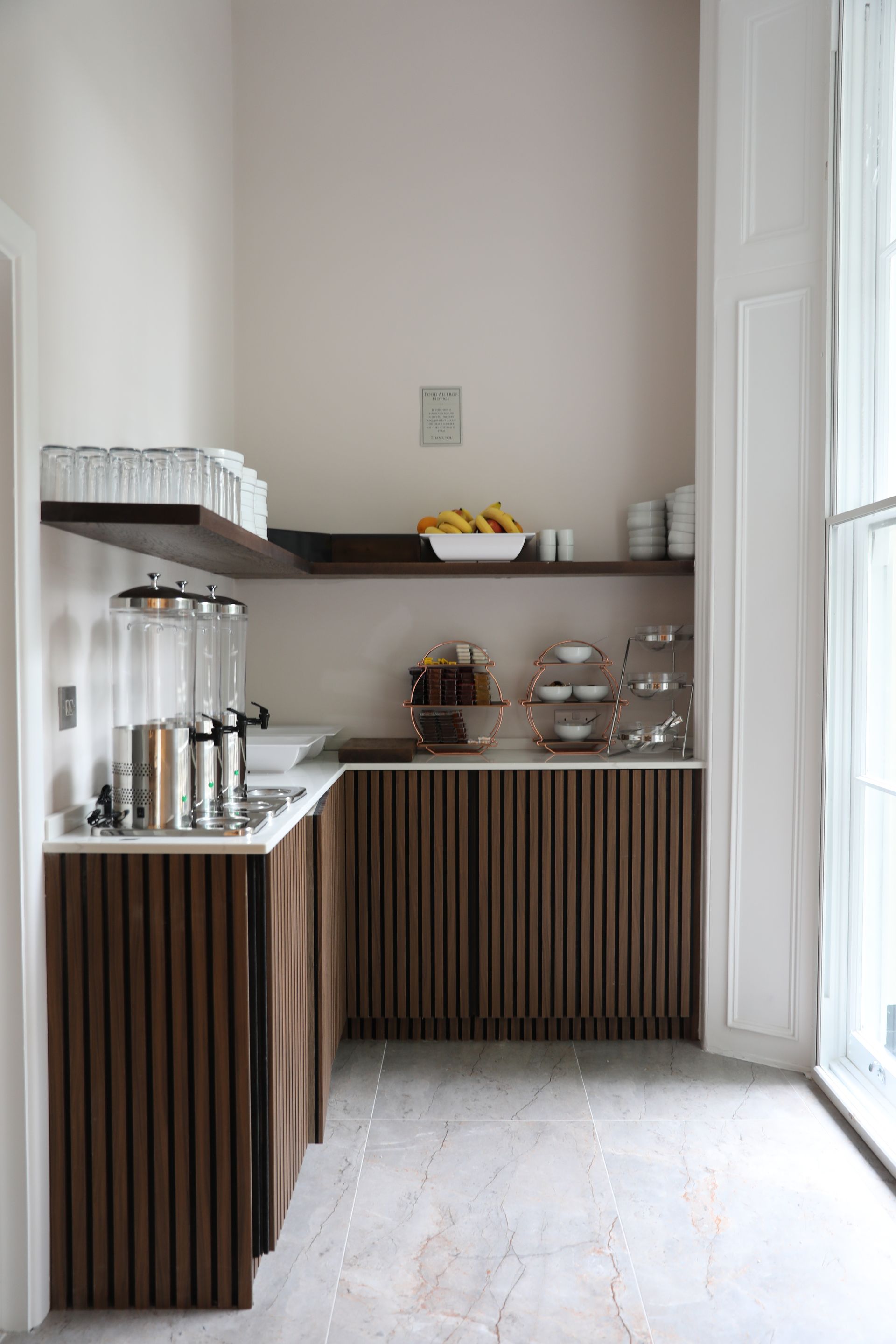 A kitchen with wooden cabinets and a large window.