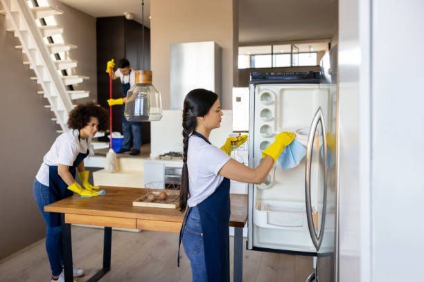 Two Women Are Cleaning A Refrigerator In A Kitchen — Cheyenne, WY — Top Mop C.