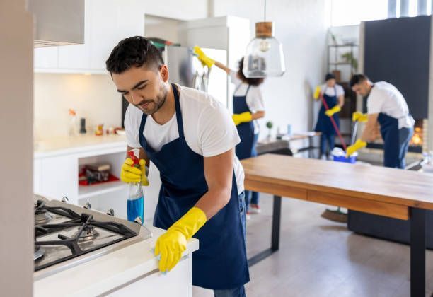 A Group Of People Are Cleaning A Kitchen Together — Cheyenne, WY — Top Mop C.