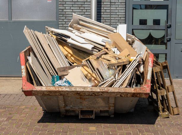A Dumpster Filled With Wood And Pallets Is Parked On A Sidewalk In Front Of A Building — Cheyenne, WY — Top Mop C.