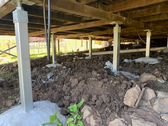 A pile of dirt and rocks under a house.