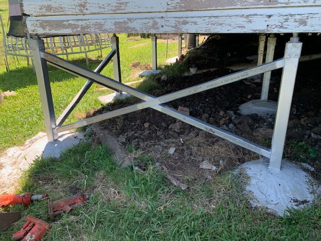 A metal structure is sitting on top of a grass covered field.