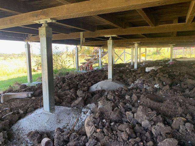 A pile of dirt is under a wooden deck.